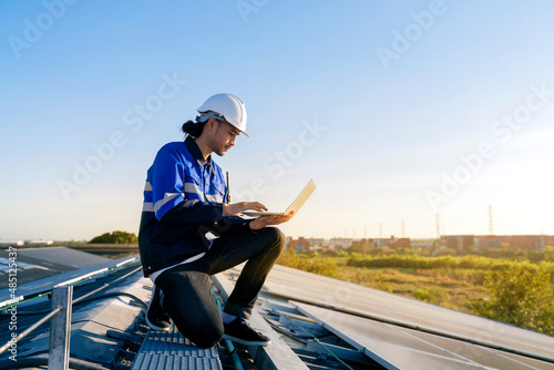 Fototapeta Specialist technician professional engineer with laptop and tablet maintenance checking installing solar roof panel on the factory rooftop under sunlight