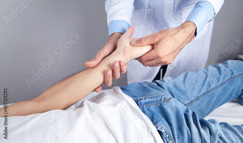 Caucasian doctor massaging patient hand.