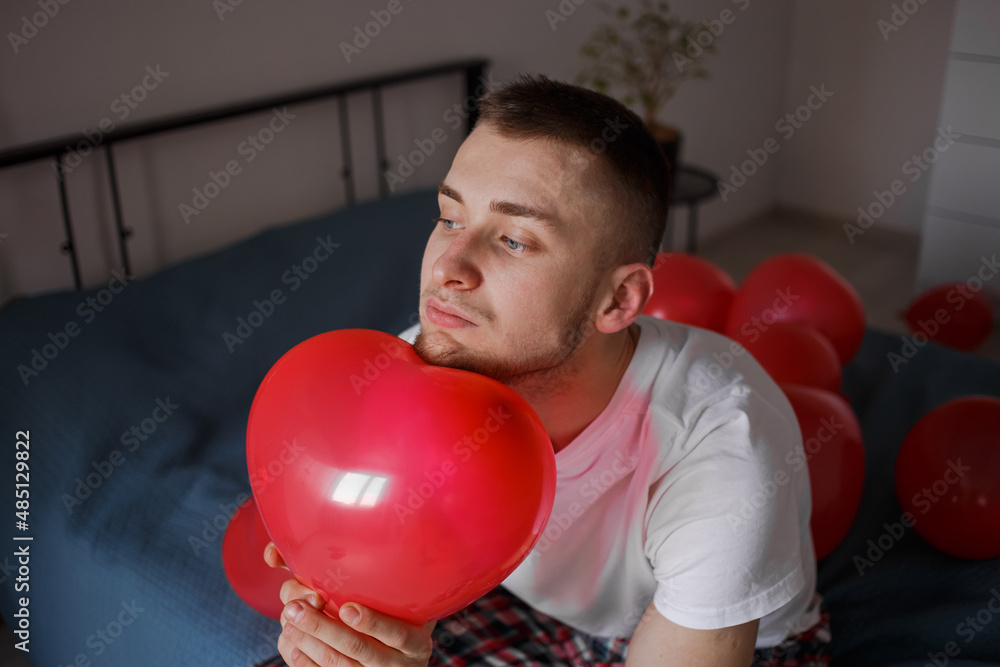 The guy holds a balloon in the form of a heart, for Valentine's Day The guy holds a balloon in the form of a heart, for Valentine's Day