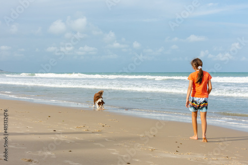 Cachorro com criança  na praia
