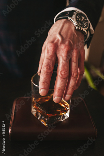 a man's hand with glasses of alcoholic beverage