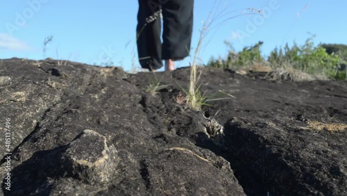 Woman walking on top of rocky hill