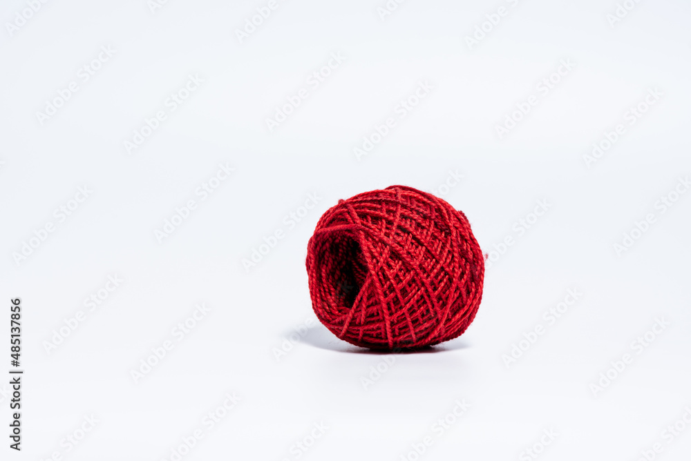 Fototapeta premium Medium size bright red ball of yarn on white background