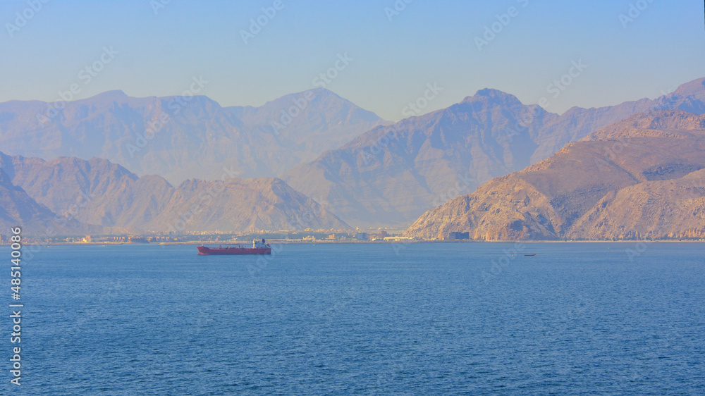 Blick auf die Küste von Khasab im Oman mit einem Schiff auf dem Meer