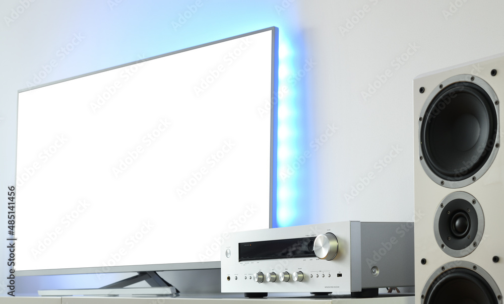 Fototapeta premium Large backlit LED TV with white screen and audio receiver in a modern apartment. 