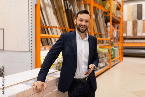 seller of laminate and flooring in a hardware store with a smile on his face