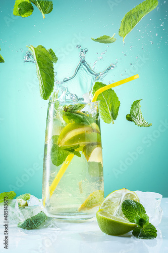 Beautiful and bright photo of a cocktail. Beverage with flying mint leaves. Cocktail splash crown. Summer beverage.