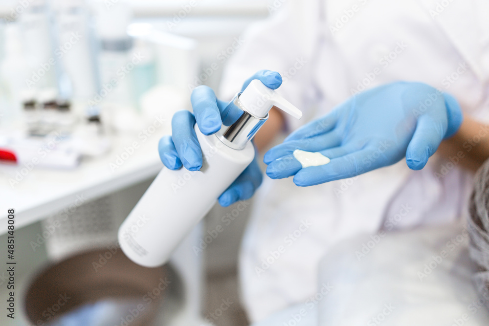 Beautician squeezes cream from tube on hand close-up Beautician squeezes cream from tube on hand close-up