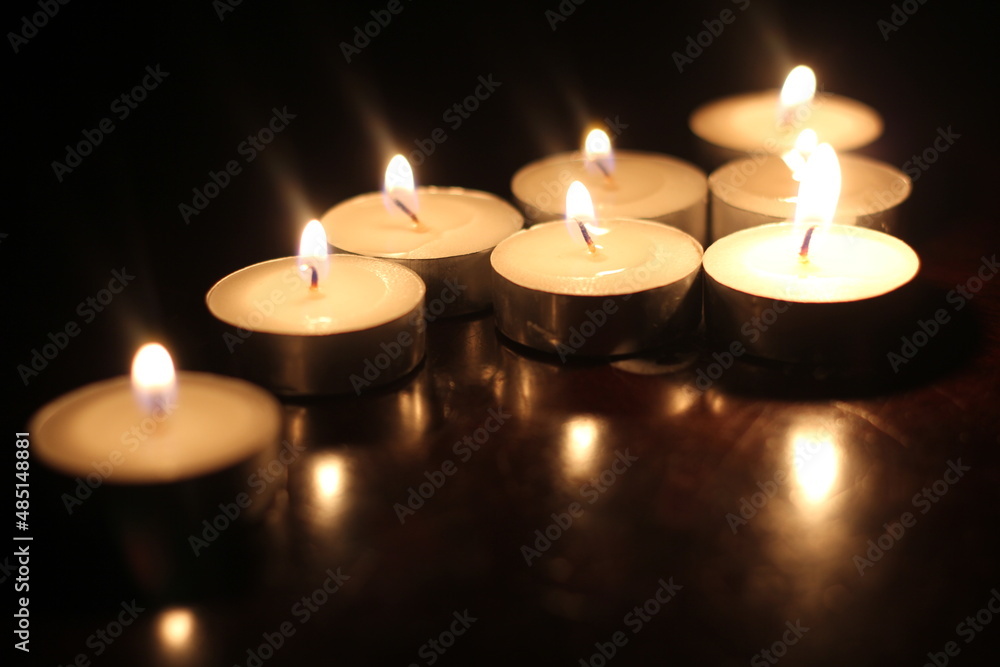 Light several candles on a wooden table Light several candles on a wooden table