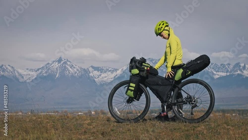 The woman travel on mixed terrain cycle touring with bikepacking. The traveler journey with bicycle bags. Sport tourism bikepacking. photo