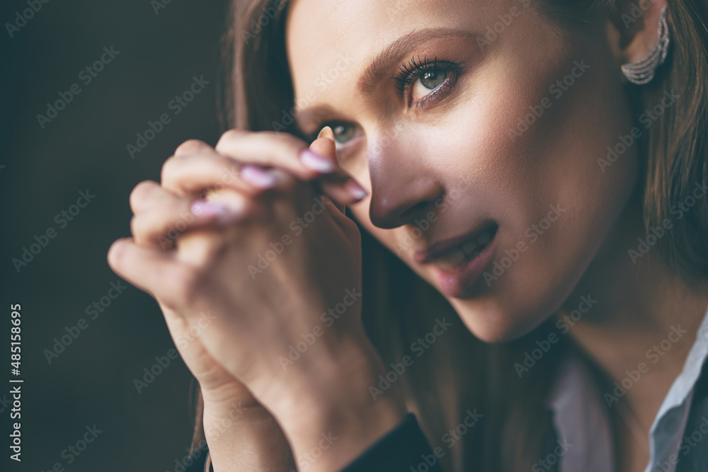 Obraz premium Close up studio Portrait of Beautiful thoughtful young woman with long hair against dark background.