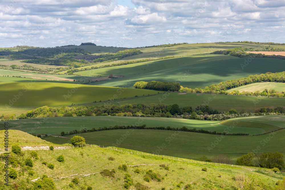 Clouds casting shadows over the South Downs hills, on a sunny spring day