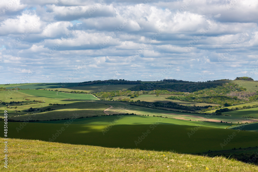 Clouds casting shadows over the South Downs hills, on a sunny spring day
