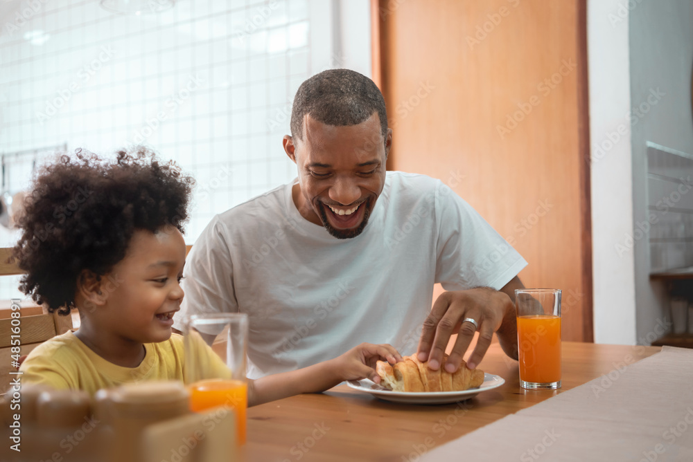 African American Father and little son playing together in breakfast at dining table African American Father and little son playing together in breakfast at dining table