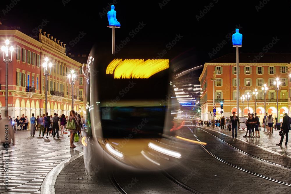 Fototapeta premium Square Massena in Nice - France at night, Avenue Jean Medecin, a lot of tourists, night illumination, statue
