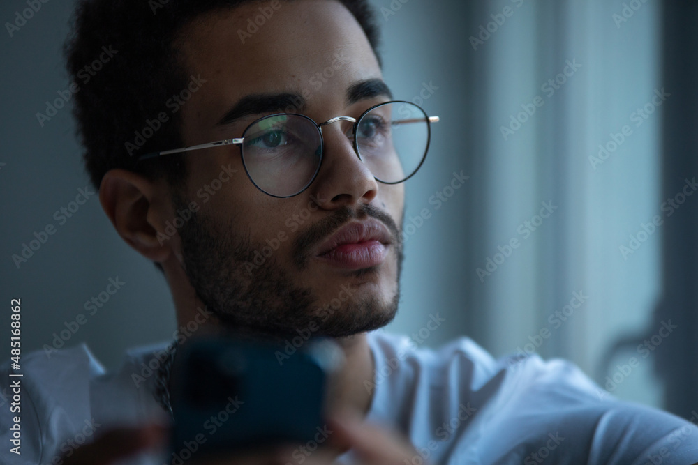 Portrait of an african american man in glasses using a smartphone. Portrait of an african american man in glasses using a smartphone.