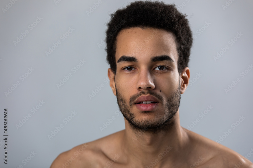 Portrait of attractive african american man with stubble and bare shoulders. Portrait of attractive african american man with stubble and bare shoulders.