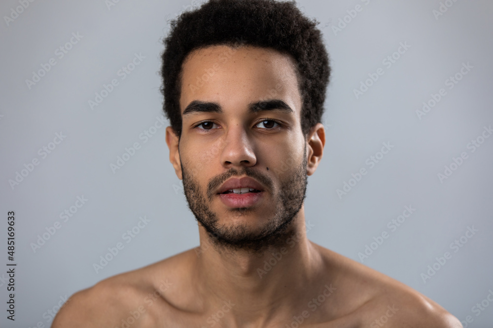 Portrait of attractive african american man with stubble and bare shoulders. Portrait of attractive african american man with stubble and bare shoulders.