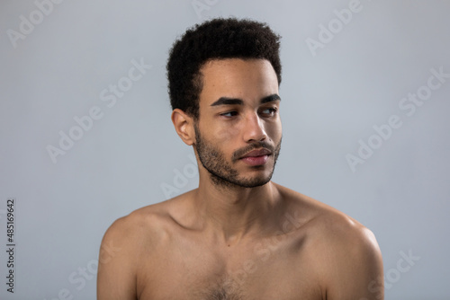 Portrait of attractive african american man with stubble and bare shoulders. photo