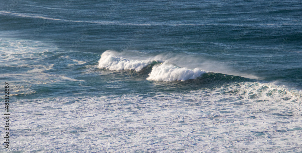 White crested waves roll into the beach at Robberg Nature Reserve from the Atlantic ocean White crested waves roll into the beach at Robberg Nature Reserve from the Atlantic ocean