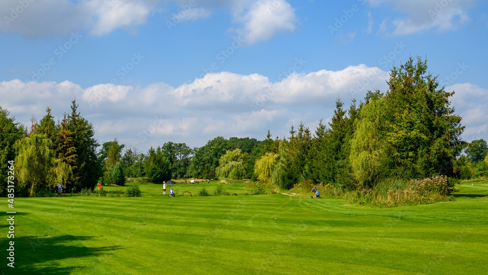 pole golfowe z graczami w oddali