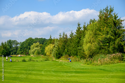 pole golfowe z graczami w oddali