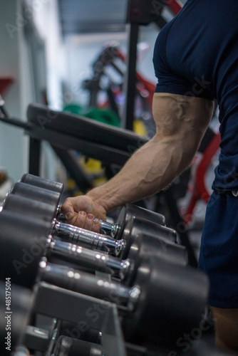  man in the gym doing a biceps exercise with a dumbbell