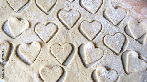 Hearts in soft rolled dough with a wooden rolling pin for valentine's day