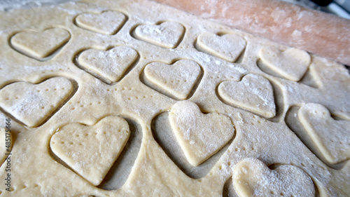 Hearts in soft rolled dough with a wooden rolling pin for valentine's day