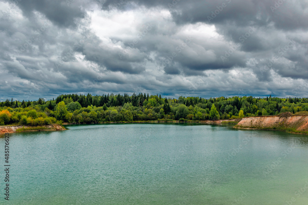lake near the forest on a cloudy gloomy summer day