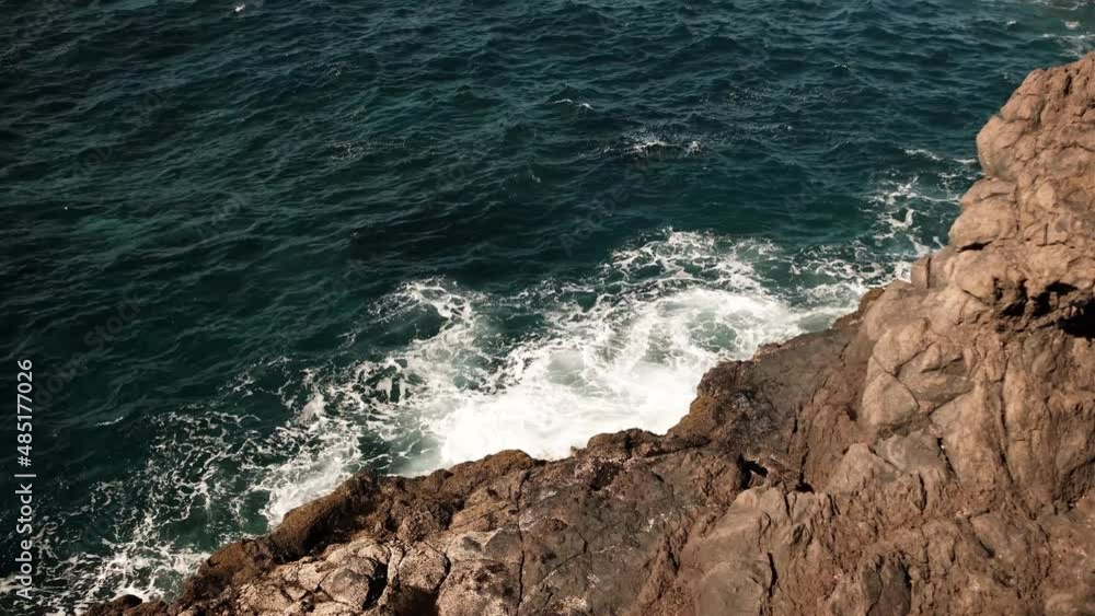 Picturesque large wave in ocean crashes against rocks splashes Picturesque large wave in ocean crashes against rocks splashes