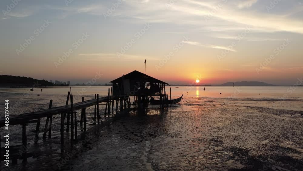 Fly toward a old wooden hut during low tide in sunrise morning Fly toward a old wooden hut during low tide in sunrise morning