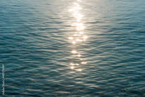 Detail of a sunlight reflecting in glittering sea. sparkler in water - background. sea water with sun glare and ripple. Powerful and peaceful nature concept