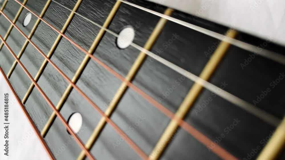 Zoom in shot of black frets fretboard acoustic guitar string. Zoom in shot of black frets fretboard acoustic guitar string.