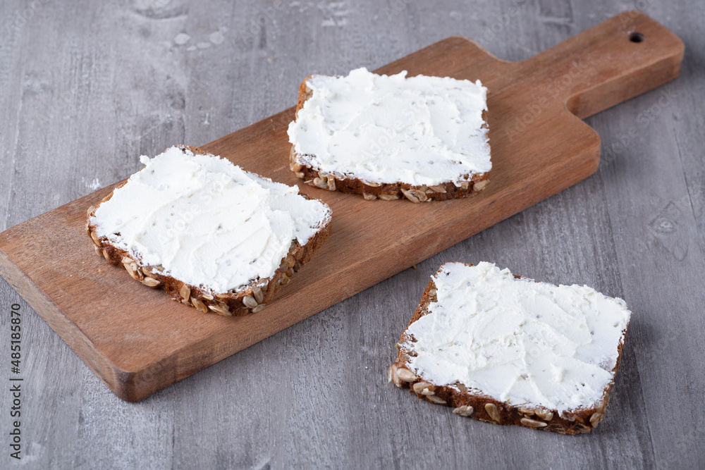 Rye bread with cream cheese on grey table Rye bread with cream cheese on grey table