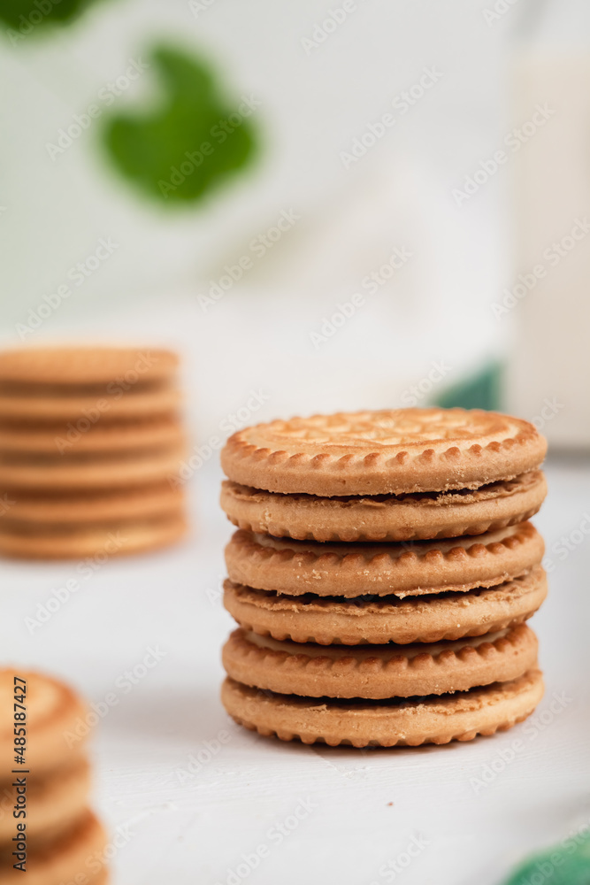 Stack of sweet sandwich cookies and bootle of milk on a white background. Breakfast concept. Stack of sweet sandwich cookies and bootle of milk on a white background. Breakfast concept.
