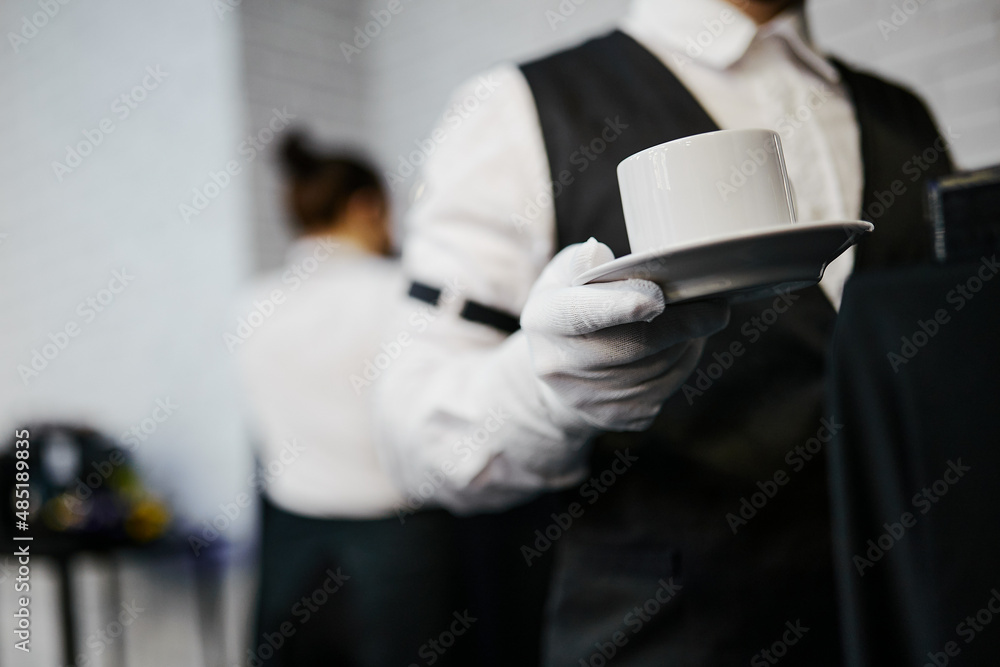 bartender holding white mugs with coffee