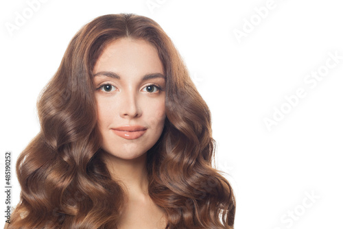 Beautiful young woman with long brown wavy hair isolated on white background