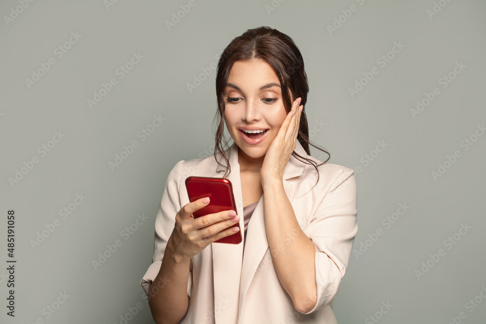 Portrait of young beautyful happy excited woman with phone. Surprised female model with smartphone Portrait of young beautyful happy excited woman with phone. Surprised female model with smartphone