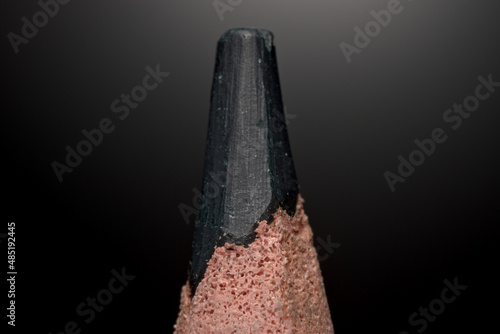 A sharpened crayon close-up macro with visible details on a black background.