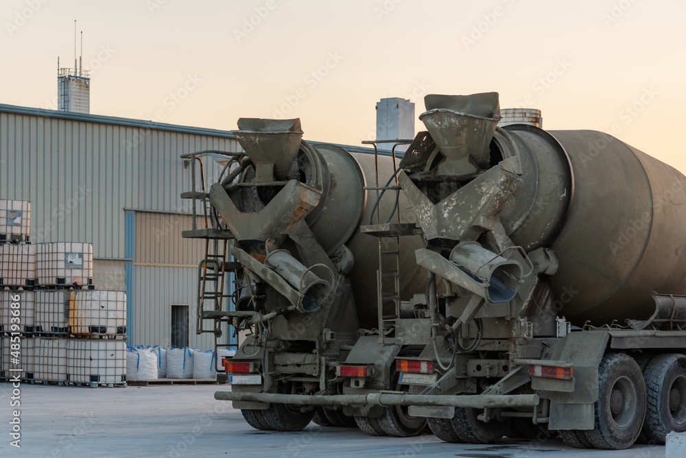 Two concrete mixer trucks seen from behind.