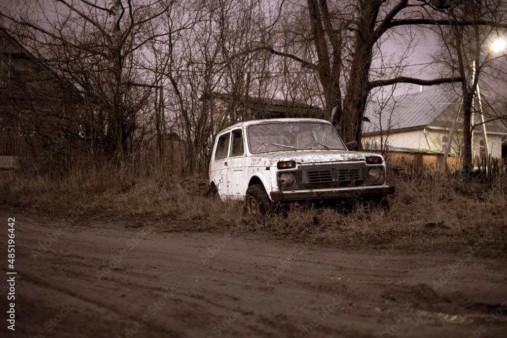 an old abandoned white car standing in the village