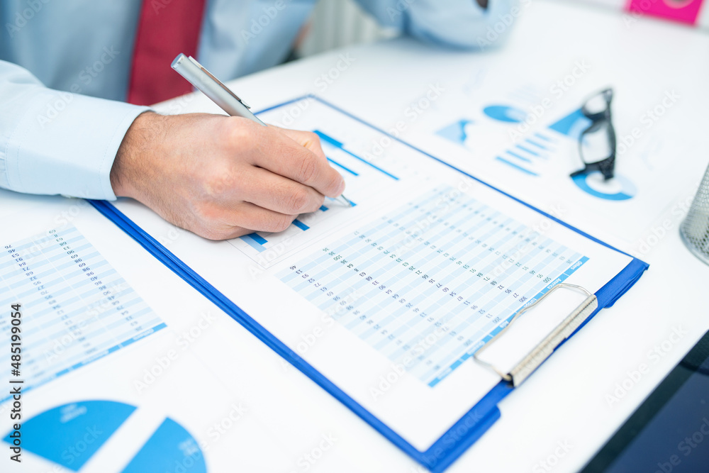 Man writing on a business document Man writing on a business document