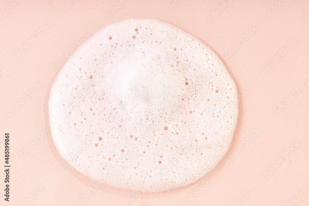 Cleansing foam with bubbles on beige background. Hygiene healthcare background. Shampoo texture Cleansing foam with bubbles on beige background. Hygiene healthcare background. Shampoo texture