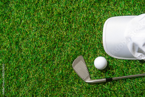 White golf ball, cap and stick on green grass. Horizontal sport poster, greeting cards, headers, website