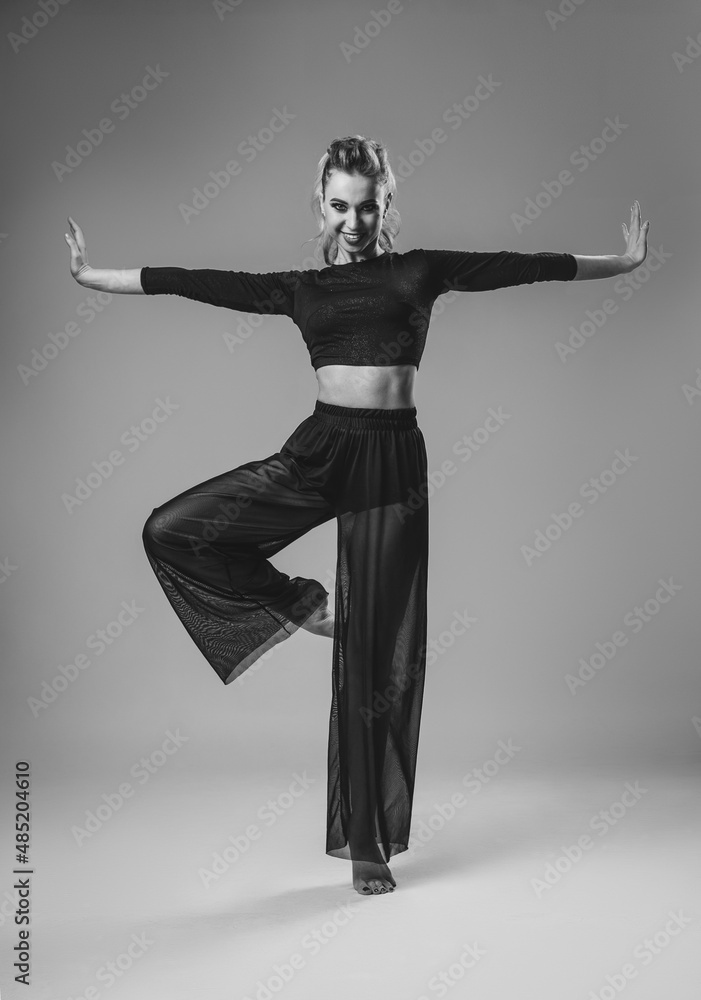 Beautiful woman contemporary dancer posing on gray studio background. Flexible sexy woman. Black and white Beautiful woman contemporary dancer posing on gray studio background. Flexible sexy woman. Black and white