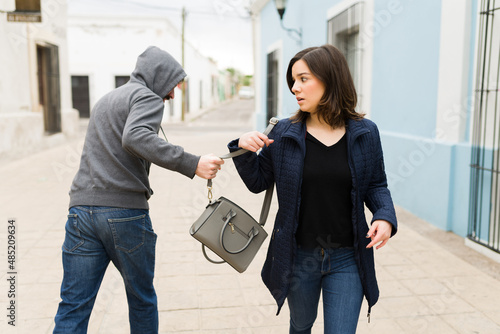 Man robbing a handbag from a scared woman photo