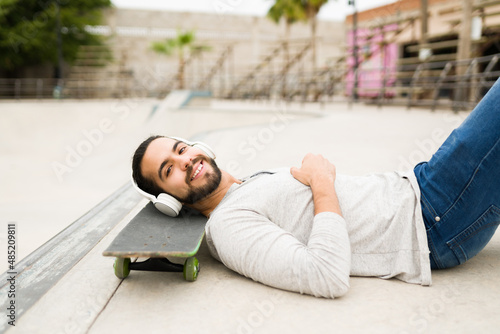 Handsome man resting on a skateboard