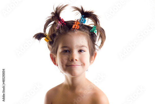 Landscape portrait of funny boy or girl with hair clips on white background.