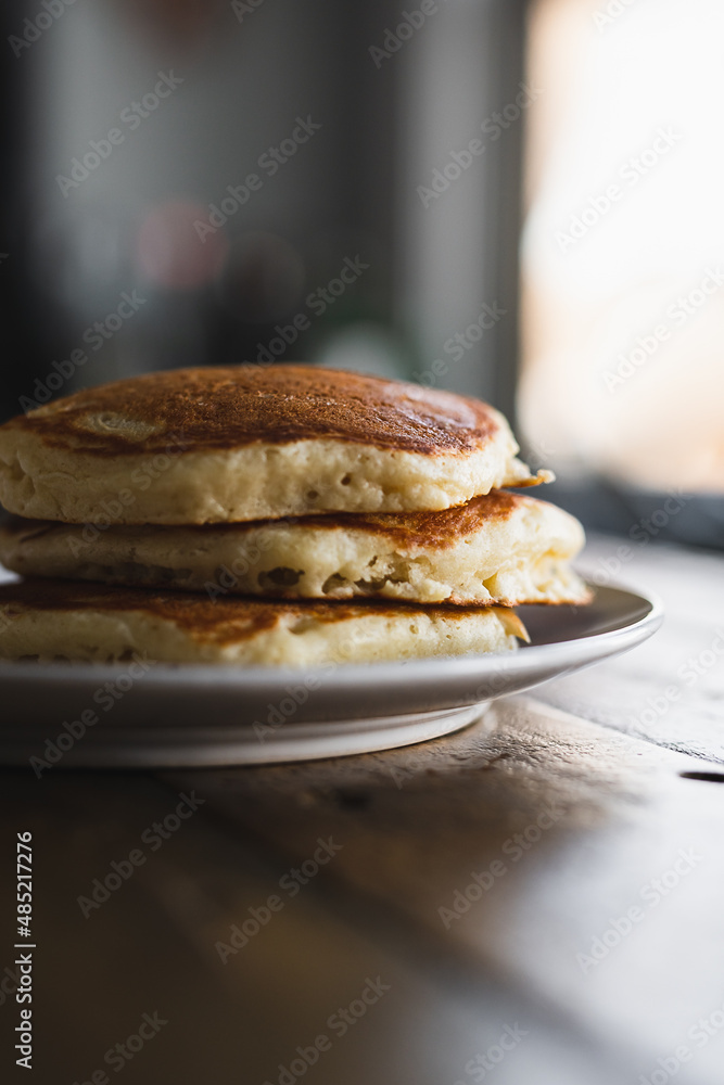 Short Stack of Pancakes on Wooden Table in Morning Light. Cooking Breakfast Lifestyle. Short Stack of Pancakes on Wooden Table in Morning Light. Cooking Breakfast Lifestyle.